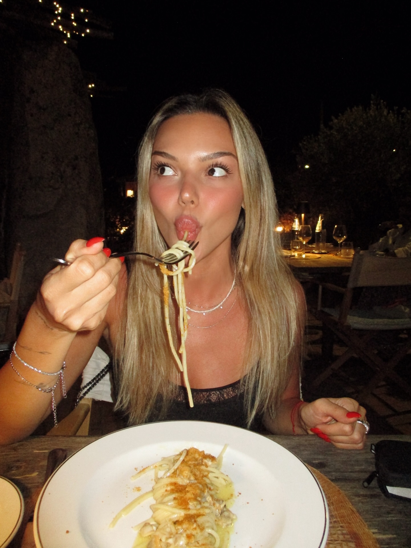 Simla enjoying pasta at an outdoor evening dinner